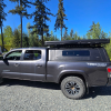 Toyota Tacoma 2016–2023 truck canopy mounted on bed with sleek black finish, ideal for secure storage and overlanding adventures