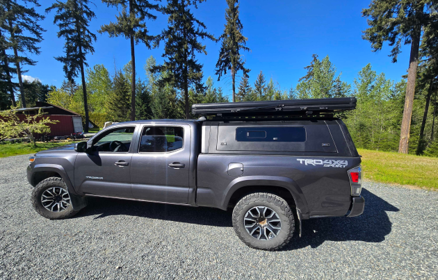 Toyota Tacoma 2016–2023 truck canopy mounted on bed with sleek black finish, ideal for secure storage and overlanding adventures