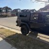 Premium aluminum gullwing truck canopy for Jeep Gladiator 2021+ in matte black, designed for overlanding, secure storage, rooftop tent mounting, and all-season Canadian conditions.