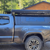 Toyota Tacoma 2016–2023 truck canopy mounted on bed with sleek black finish, ideal for secure storage and overlanding adventures