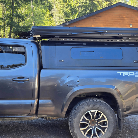 Toyota Tacoma 2016–2023 truck canopy mounted on bed with sleek black finish, ideal for secure storage and overlanding adventures