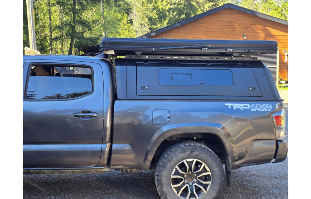Toyota Tacoma 2016–2023 truck canopy mounted on bed with sleek black finish, ideal for secure storage and overlanding adventures