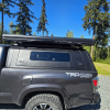 Toyota Tacoma 2016–2023 truck canopy mounted on bed with sleek black finish, ideal for secure storage and overlanding adventures