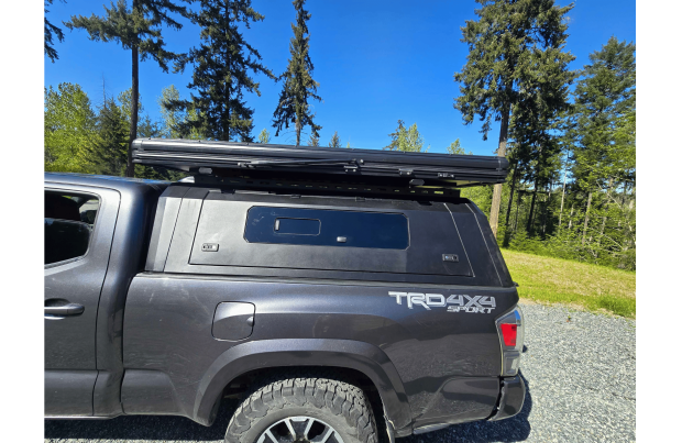 Toyota Tacoma 2016–2023 truck canopy mounted on bed with sleek black finish, ideal for secure storage and overlanding adventures