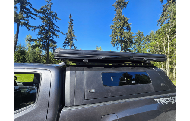 Toyota Tacoma 2016–2023 truck canopy mounted on bed with sleek black finish, ideal for secure storage and overlanding adventures
