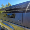 Toyota Tacoma 2016–2023 truck canopy mounted on bed with sleek black finish, ideal for secure storage and overlanding adventures