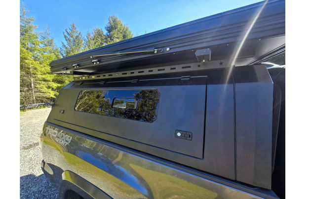 Toyota Tacoma 2016–2023 truck canopy mounted on bed with sleek black finish, ideal for secure storage and overlanding adventures